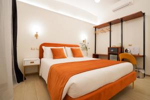 a bedroom with a large bed with an orange blanket at Charm&Bella GuestHouse in Rome
