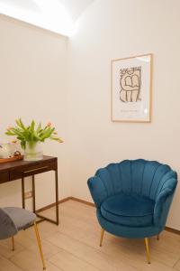 a blue chair in a living room with a table at Charm&Bella GuestHouse in Rome