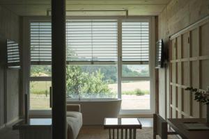 a room with a large window with a tub and a couch at Hotel Amiuka in O Pedrouzo