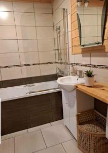 a bathroom with a sink and a bath tub and a sink at Wrzos Chata w Beskidach in Kamesznica