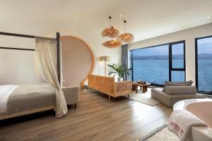 um quarto com uma cama e uma sala de estar com o oceano em Dali Beauty Seaview B&B em Dali