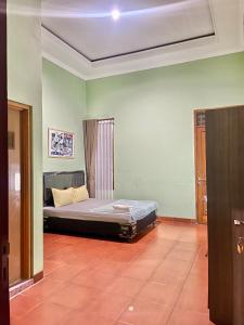 sypialnia z łóżkiem w środku pokoju w obiekcie Telu.Telu Solo w mieście Surakarta