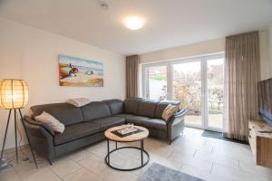 a living room with a couch and a table at Ferienhaus Auszeit in Borkum