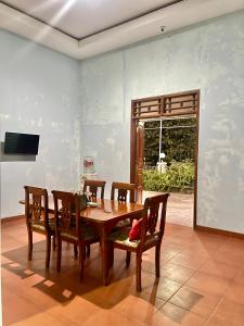 a dining room with a wooden table and chairs at Telu Telu Solo in Solo +29 photos