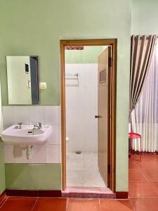 een badkamer met een wastafel en een douche bij Telu.Telu Solo in Solo