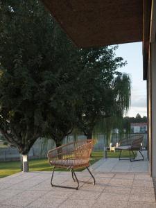 two benches sitting on a sidewalk in a park at Hotel Amiuka in O Pedrouzo