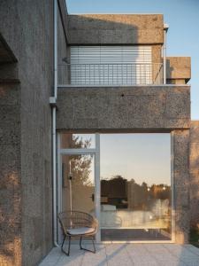 a glass door of a building with a chair at Hotel Amiuka in O Pedrouzo