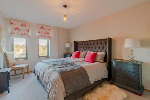 海怡的住宿－Outshot Barn，卧室配有一张带粉红色枕头的大床