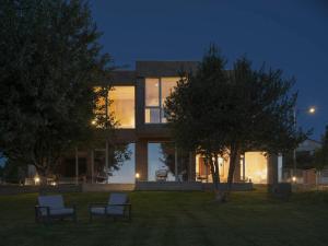 a building with two chairs in front of it at night at Hotel Amiuka in O Pedrouzo