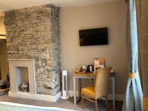 a room with a table and a stone fireplace at Snooty Fox in Kirkby Lonsdale