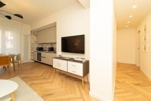 a living room with a television and a kitchen at Esclusivo appartamento con 2 camere da letto in Milan