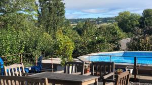 a patio with a table and chairs and a swimming pool at Outshot Barn in Hay-on-Wye