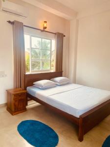 a bedroom with a large bed with a window at Devo's place in Galle