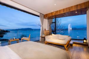 1 dormitorio con cama y ventana grande en Dali Beauty Seaview B&B, en Dali