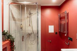a shower in a bathroom with red walls at Cosy Central Studio Apt. - Near Old Town in Riga