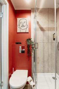 a red bathroom with a toilet and a shower at Cosy Central Studio Apt. - Near Old Town in Riga