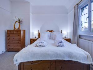 um quarto com uma cama grande e lençóis brancos em Pass the Keys Charming 2 Bedroom House Good Transport and Parking em Londres