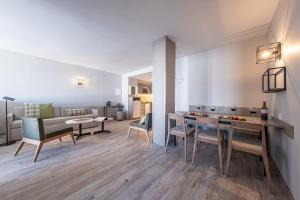 een keuken en een woonkamer met een tafel en stoelen bij Apartamentos Caribou in Pas de la Casa