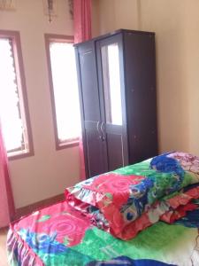 een slaapkamer met een bed en een kast bij KHAIRI HOMESTAY in Bukittinggi