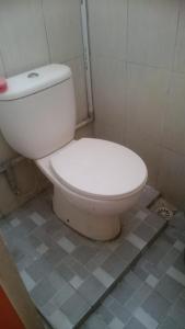 een badkamer met een wit toilet in een kamer bij KHAIRI HOMESTAY in Bukittinggi
