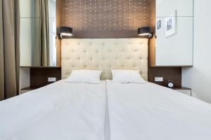 a large white bed with two pillows on it at Elite Apartments Rezydencja Marina in Gdańsk