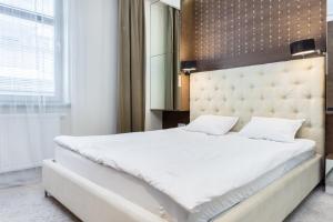 sypialnia z dużym białym łóżkiem i lustrem w obiekcie Elite Apartments Rezydencja Marina w Gdańsku