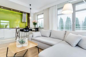 salon z białą kanapą i kuchnią w obiekcie Elite Apartments Rezydencja Marina w Gdańsku
