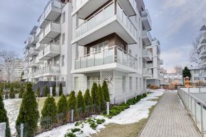 een appartementencomplex met een witte gevel bij Elite Apartments Rezydencja Marina in Gdańsk