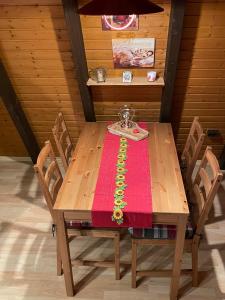 een houten tafel met een rode tafelkleed erop bij Villa Königsdorf am See in Waldkirchen