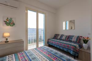 a bedroom with a bed and a balcony at Onde in Triscina