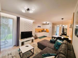 a living room with a couch and a tv at Apartament Turkusowy w Mielnie in Mielno