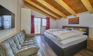 - un salon avec un lit et un canapé dans l'établissement Good Life Top 3, à Saalbach-Hinterglemm