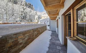 une passerelle devant une maison dans la neige dans l'établissement Good Life Top 3, à Saalbach-Hinterglemm