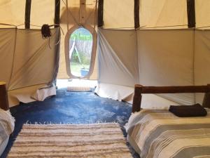 Postel nebo postele na pokoji v ubytování Tsitsikamma Wolf Sanctuary ECO Cabins & Teepees