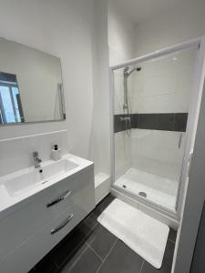 La salle de bains blanche est pourvue d'une douche et d'un lavabo. dans l'établissement Appartement Cosy Centre ville Marseille wifi, à Marseille
