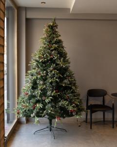 een kerstboom in de hoek van een kamer bij Triumf Hotel in Prizren