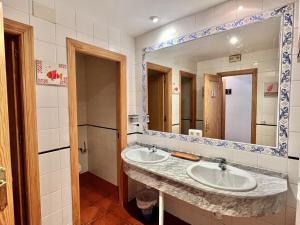 a bathroom with two sinks and a large mirror at Hostal Nomadas in Cuenca