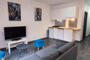 a living room with a couch and a kitchen at Chalet cosy en centre-ville in Le Puy-en-Velay +6 photos