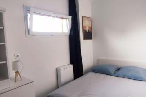a bedroom with a bed and a window at Chalet cosy en centre-ville in Le Puy-en-Velay
