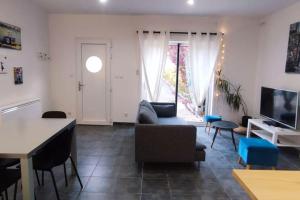 a living room with a couch and a table at Chalet cosy en centre-ville in Le Puy-en-Velay