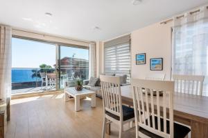 a living room with a table and chairs and a large window at Apartamento Melior 2C - PlusHolidays in Calpe
