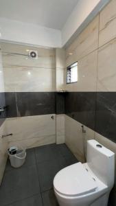 a bathroom with a white toilet and a window at Himasailam Resort in Vagamon