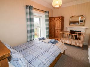 ein Schlafzimmer mit einem Bett, einem Kinderbett und einem Spiegel in der Unterkunft Alcorns Farmhouse in Letterkenny