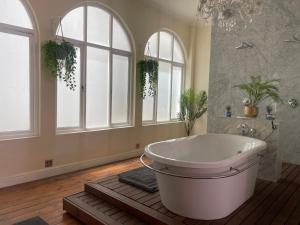 a bathroom with a large tub in a room with windows at Cosy city stay in Cape Town