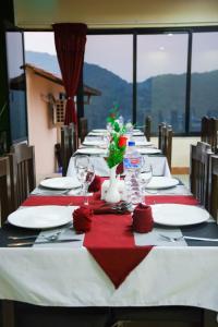 a long table with white plates and red napkins at Doleshwor Village Resort and Farm House Pvt Ltd in Bhaktapur