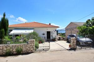 a house with a gate and a car parked in front at Apartment Renata in Šilo