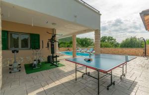 un tavolo da ping pong su un patio accanto alla piscina di Beautiful Home In Konjsko With Outdoor Swimming Pool a Konjsko