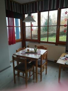 a dining room with a table and chairs and windows at Arberblick in Schöfweg