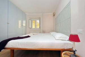 ローマにあるMonti Studioの白いベッドルーム(ベッド1台、赤いランプ付)