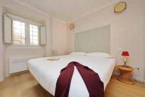 ローマにあるMonti Studioのベッドルーム1室(大きな白いベッド1台、窓2つ付)